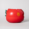 apple ceramic pencil cup laying on its side with 'bite' taken out of the top with 'easy does it' fruit sticker on the side
