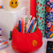 apple ceramic pencil cup laying on its side with 'bite' taken out of the top with 'easy does it' fruit sticker on the side with pencils inside