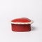 side view of ceramic heart shaped trinket box with white scalloped trim and cursive 'everything' in the inside