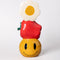 stacked vase with white flower, an apple on it's side and smiley face