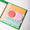 various colorful and shaped sticky notes inside of green sticky note folio with white 'sticky notes' on the front with colorful shaped and gold string closure