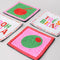 up close of set of 4 beaded coasters: green beaded with cherry print, white with colorful beaded 'tres bien!', white with colorful beaded 'ooh lala', and pink with beaded olive.