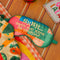 colorful patchwork eye mask with cream 'shhhh...can't you hear i'm snoring?' across the front on a table