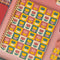 pink, yellow, teal and cream checkered mini notebook with colorful tulip back cover on a pink background