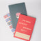 set of three small notebooks: multicolor plaid, simple pink tulip and red with 'for some serious business only!' across the front