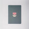 green notebook with pink cartoon-y tulip print
