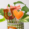 up close of set of 4 plant stakes: orange heart, pink cowboy boot, brown horseshoe, and pink bow