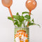 set of 2 glass peach watering globes in a planter