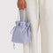 model holding mist drawstring bag
