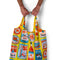 model holding yellow reusable bag with blue and red tinned can theme