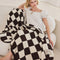 model with cream and espresso brown checkered blanket laying over them
