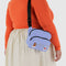 model wearing cornflower fanny pack with embroidered miffy and star print with black strap and zipper trim over their shoulder