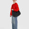 model wearing black large crescent bag with interior key leash