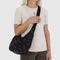 model carrying black medium crescent bag with red painted wildflower print