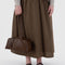 model holding medium brown recycled dome bowler bag with silver charm clasp