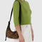 model wearing dark brown leather small crescent bag with black strap