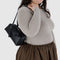 model carrying black small dome recycled leather bowler bag with silver charm clasp