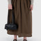 model holding black small dome recycled leather bowler bag with silver charm clasp