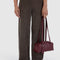 model holding mahogany small dome recycled leather bowler bag with silver charm clasp