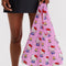 model carrying pink standard baggu with hello kitty and yellow tulip print