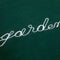up close of dark green sweatshirt with white chainstitch garden enthusiast across the front