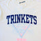 up close of vintage white tee with navy TRINKETS across the front