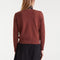 back view of model wearing brown sweater with textured orange heart on the left bust