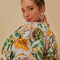 up close of model wearing white cropped blouse with mixed fruit print and slight puff sleeves