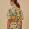 back view of model wearing white cropped blouse with mixed fruit print and slight puff sleeves