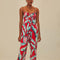 model wearing red tank jumpsuit with green leaf print and cuffed leg openings
