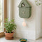 olive hanging cuckoo clock with peach dial and trim on a wall