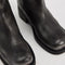up close of model wearing black distressed leather pull-on tall boots