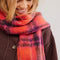 up close of model wearing red scarf with pink and purple stripes and beading detail