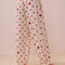 back view of model wearing white relaxed fit PJ pants with different shaped red dots