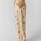 side view of model wearing cream pinstripe balloon lounge pants with yellow dainty floral print