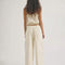 back view of model wearing cream relaxed fit jeans with elastic waist and drawstring