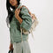 model carrying mini washed beige leather purse with several zippered pockets, double handles and crossbody strap
