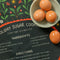 up close of green tea towel with holiday sugar cookies with red floral and partridge print