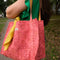 model carrying pink quilted floral tote bag with yellow printed interior