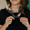 model wearing black square cotton bandana with colorful peach poppy flower print around their neck