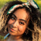 model with cream square bandana with dark teal green, blue, cream, red flowers tied in their hair