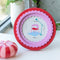 red round photo frame with pink scalloped interior on a table