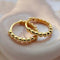 side view of gold pebble hoop earrings