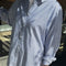 model wearing relaxed fit blue and white vertical stripe button front shirt