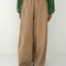 model wearing khaki parachute pants with elastic waist and side pockets