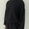 model wearing black colored waffle sweatshirt with slight balloon sleeves