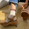 model wearing cream crew socks with brown and black trim and sandals