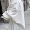 side view of model wearing white relaxed fit button front shirt with side vents and collar