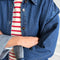 up close of model wearing oversized dark denim button down shirt with striped tee and white pants