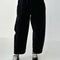 model wearing black corduroy arc pants with side panels and pockets